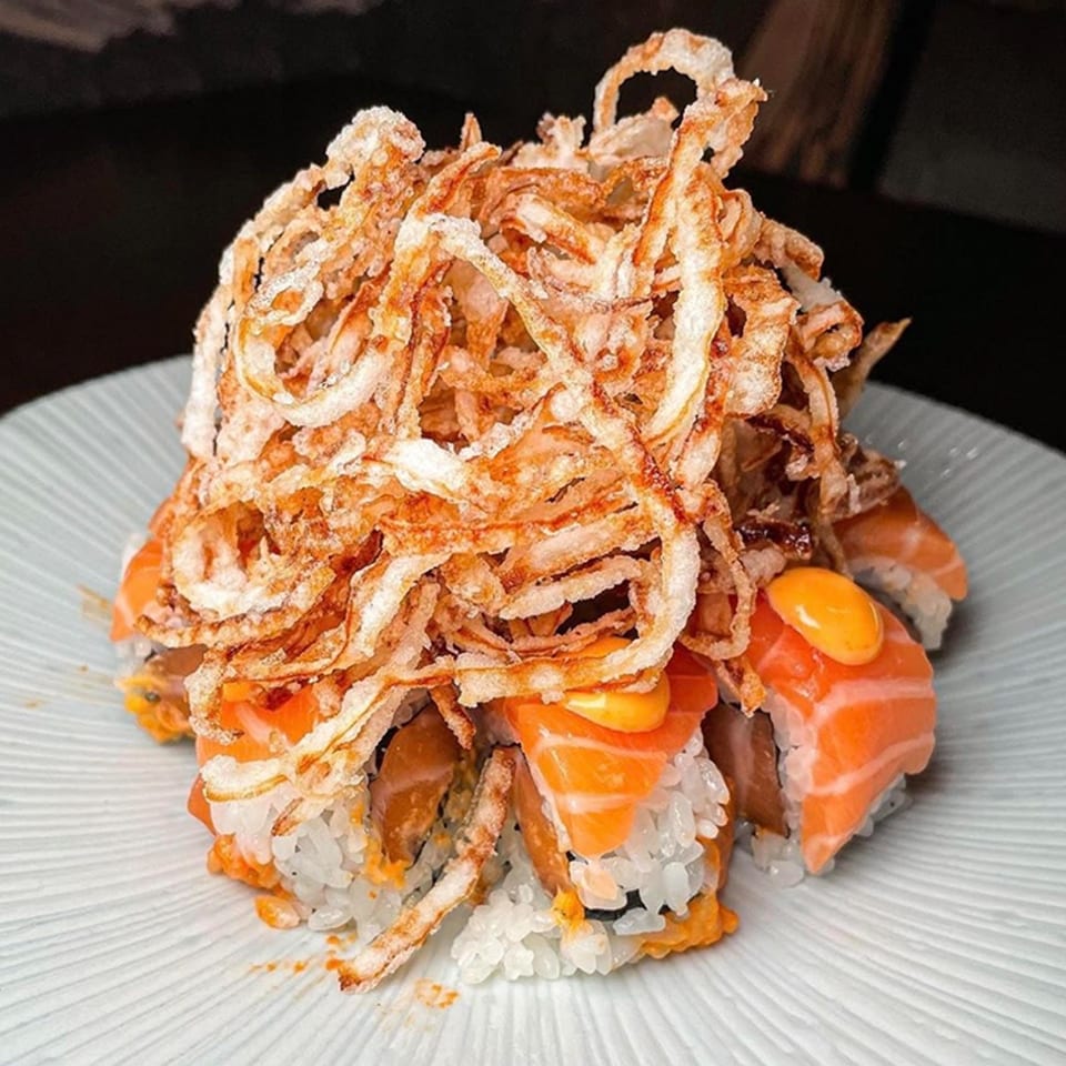 Tomoya Sushi & Izakaya's salmon sushi rolls topped with crispy fried onions and orange sauce.